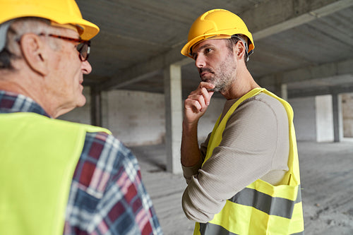 Back view of two caucasian engineers discussing on construction site
