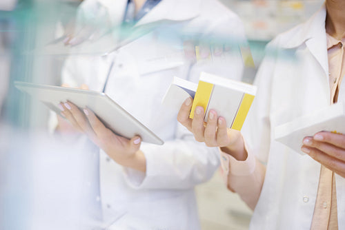 Pharmacists taking stock with digital tablet