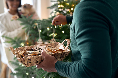 Close up of basket full of Christmas tree decorations in man's hands