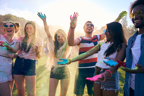 Friends having fun during music festival with colour powders