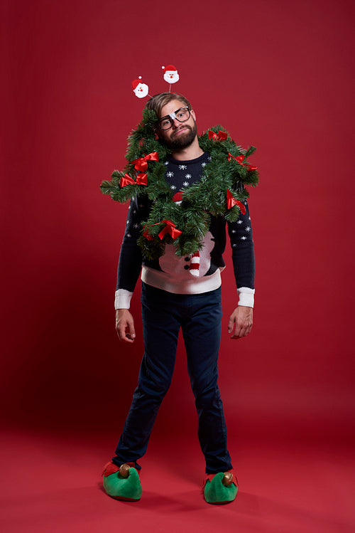 Man wearing christmas clothes and a garland
