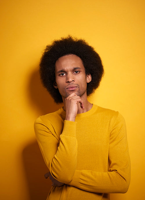 Portrait of thoughtful Afroamerican in yellow