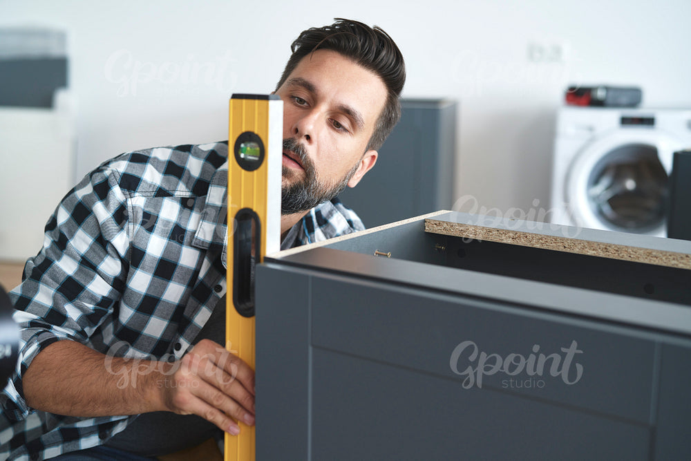 Carpenter checking the furniture levels using a spirit level