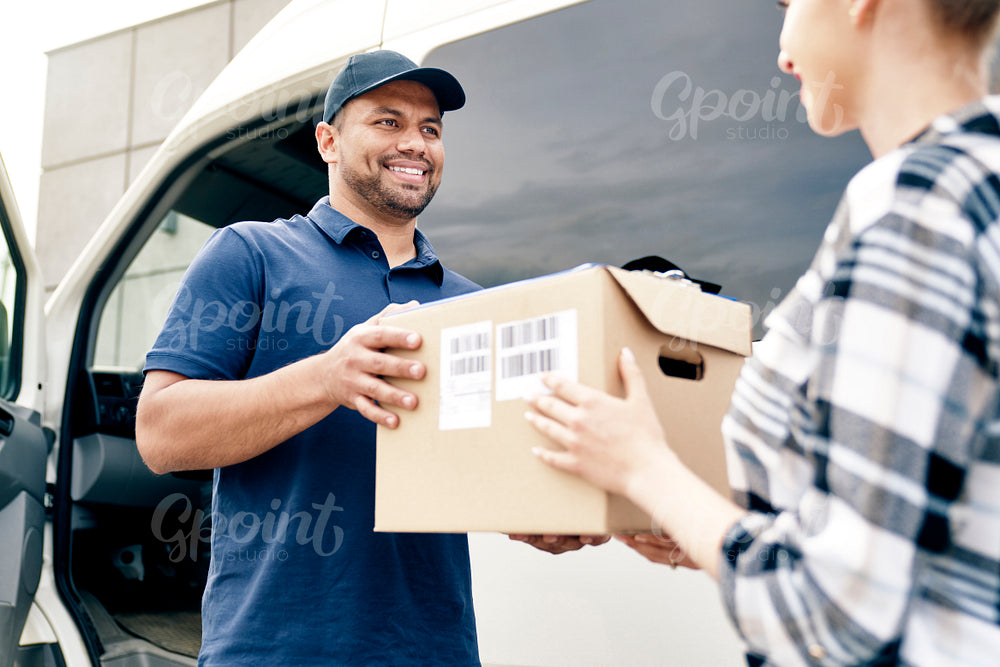 Delivery person giving boxes to woman