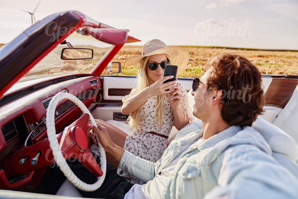 Couple taking pictures of themselves during a road trip