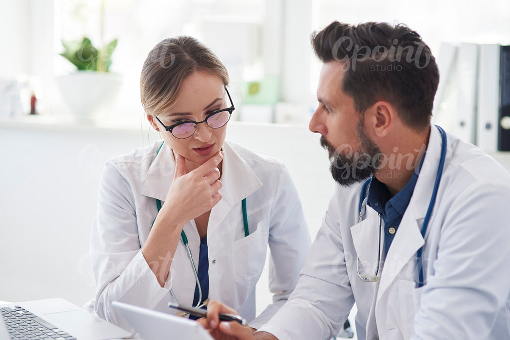 Two busy doctors talking in doctor’s office