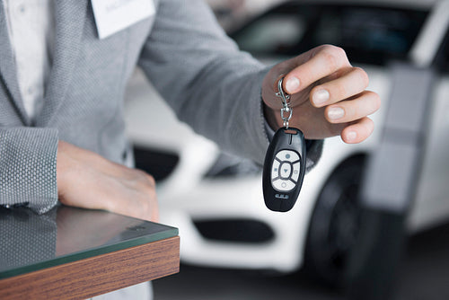 Main view of salesman holding car keys