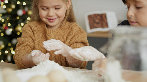 Close up video of children using flour on bakeboard
