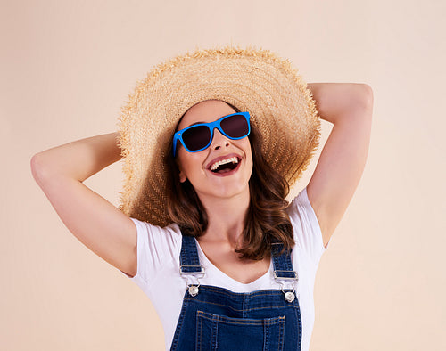 Portrait of joyful woman with sunglasses and sun hat