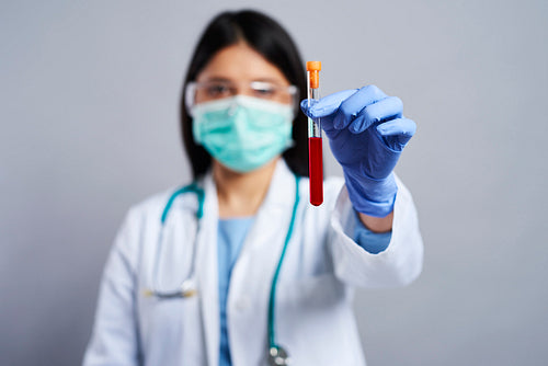 Female doctor holding a test tube with blood