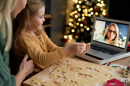 Granddaughter showing her grandma Christmas cookies during a video conference