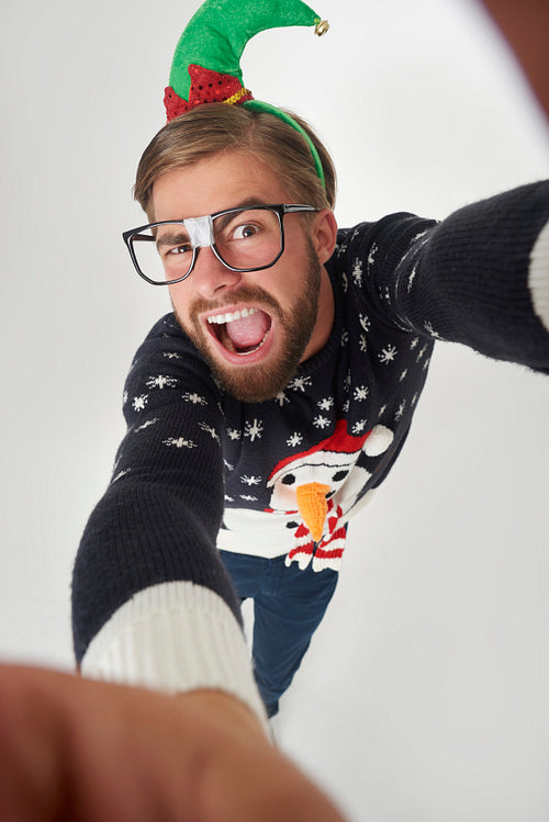 Man in Christmas clothes taking a selfie