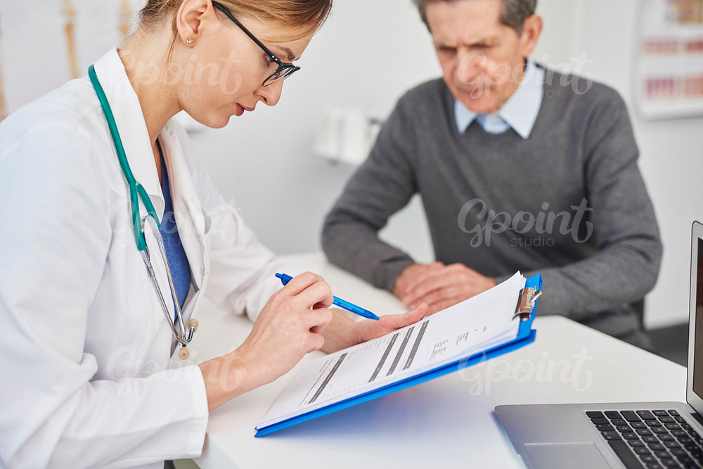 Doctor looking at results on the clipboard