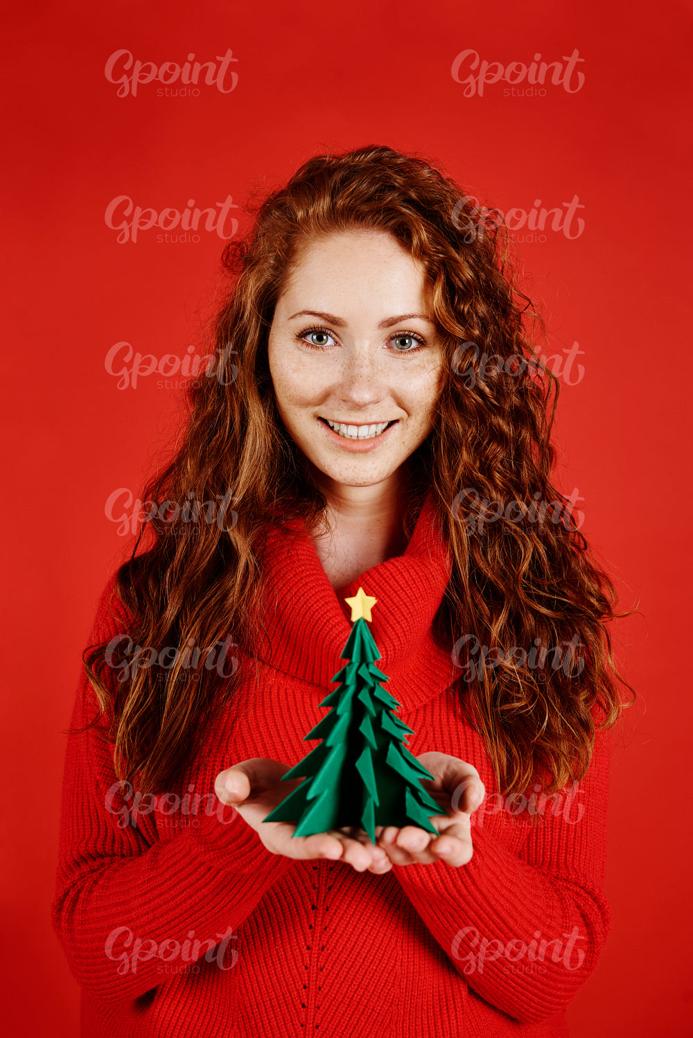 Smiling girl holding a small christmas tree