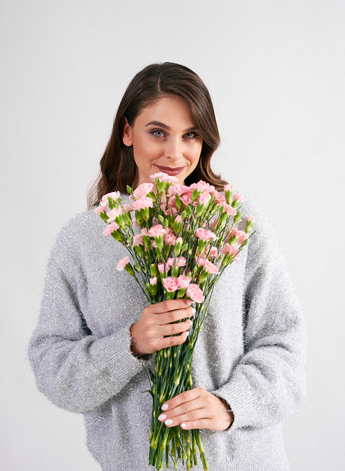 Beautiful woman holding bunch of flowers in studio shot