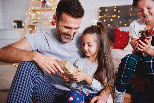 Girl giving christmas present to her father