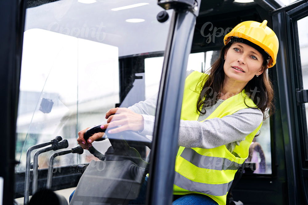 Adult caucasian woman driving a forklift 