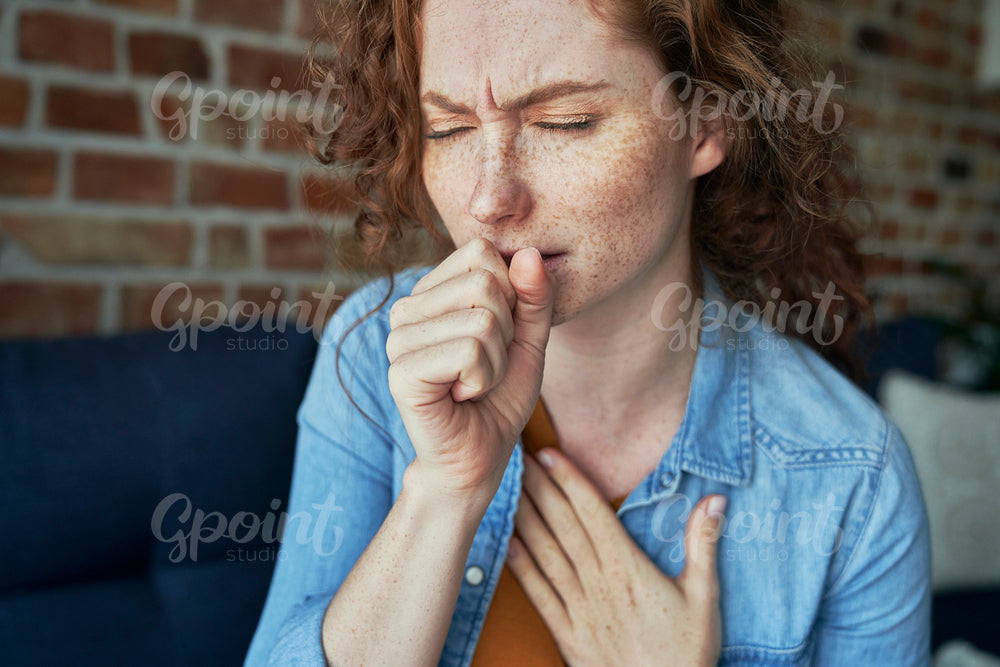 Caucasian red head woman coughing and having lungs infection