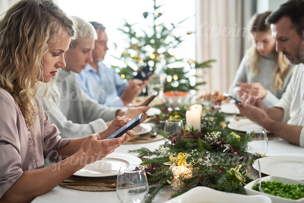 Family of caucasian people spending Christmas Eve with mobile phones 