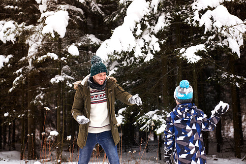 Father and son having a snowball fight in the snow