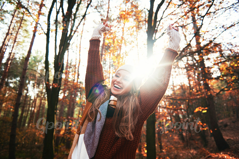 Happy beautiful young woman in autumnal forest