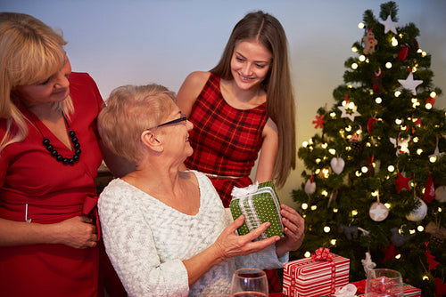 Teenage girl giving a gift to her grandmother