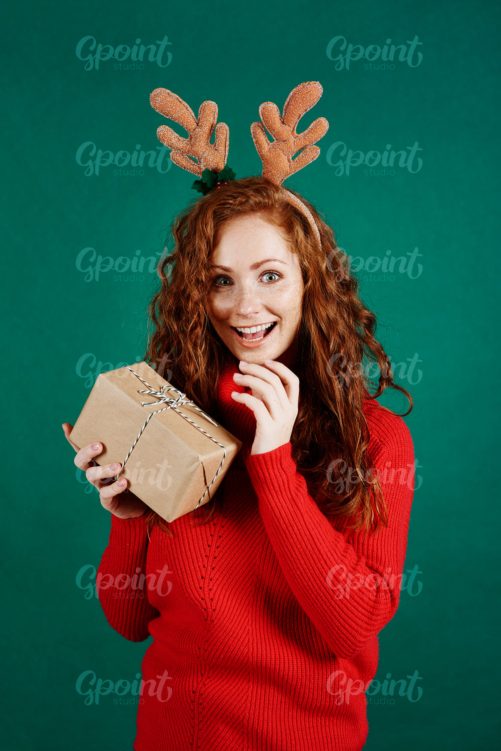 Portrait of excited woman opening christmas present