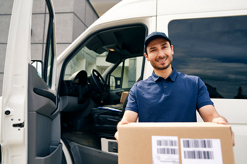 Portrait of a smiling courier giving a package