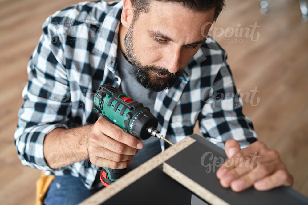 Top view of man using a cordless screwdriver