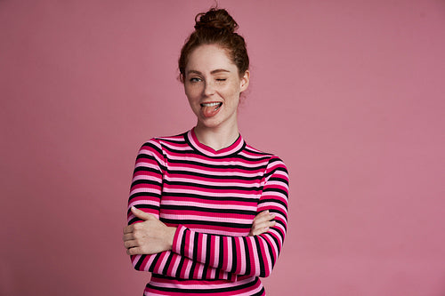 Studio shot of young girl make a funny face and standing on the pink background
