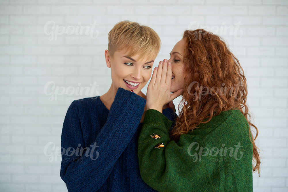 Girl whispering a secret to her friend