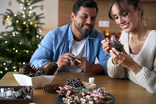 Multi ethnicity couple make a Christmas decorations at home