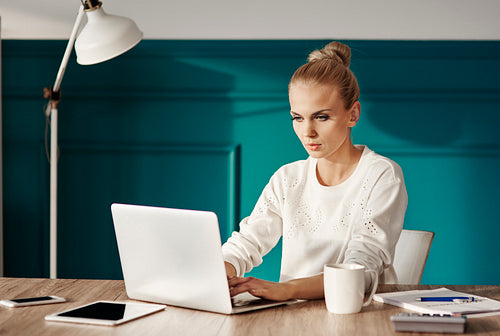 Confident businesswoman typing on laptop keyboard