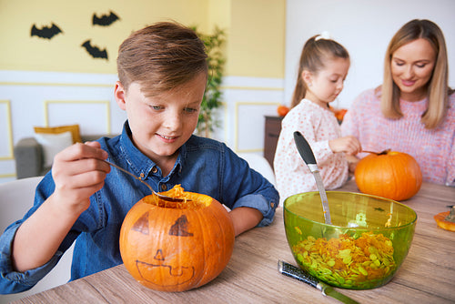 Happy boy carving pumpkin for Halloween