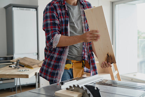 Carpenter holding the board ready to be cut