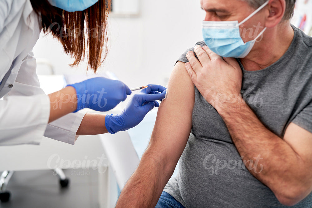 Close up of senior patient being vaccinated in a doctor's office