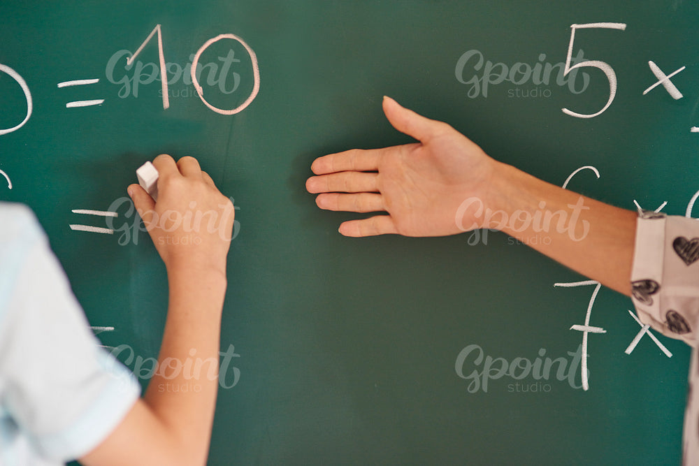 Teacher and her pupil next to the blackboard