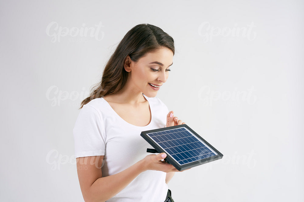 Beautiful woman holding a model of solar panel