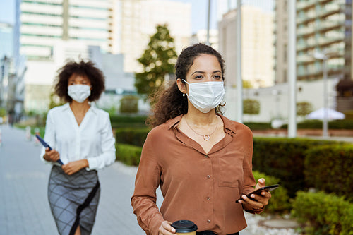 Businesswomen  walking in the city in protective face masks