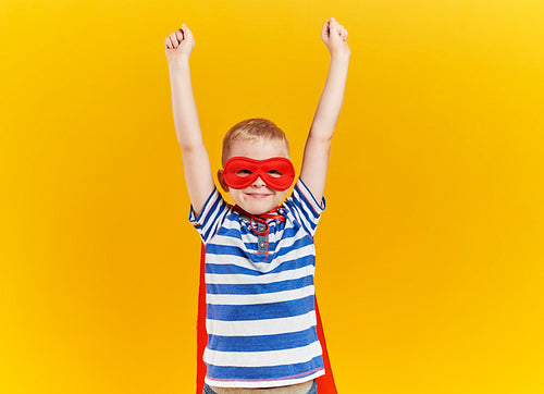 Child as superhero with hands raised