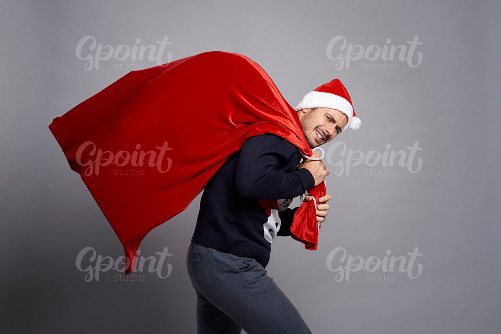 Man carrying a huge bag full of Christmas presents