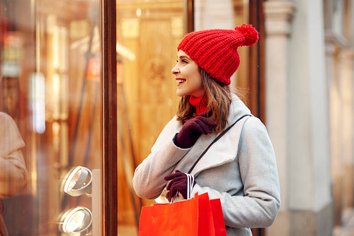 Beautiful woman looking on shop window during christmas shopping