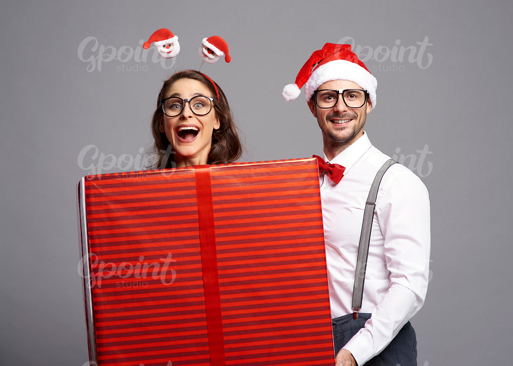 Playful couple with big Christmas gift