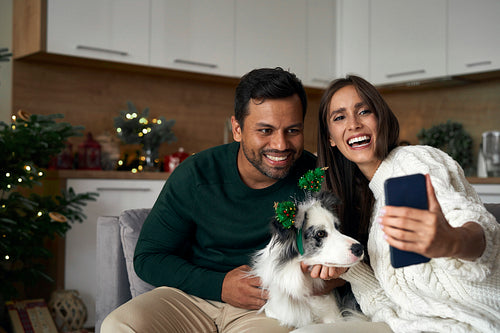 Happy couple make a selfie with dog during the Christmas