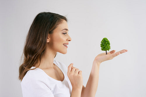 Woman holding a growing tree in her hand