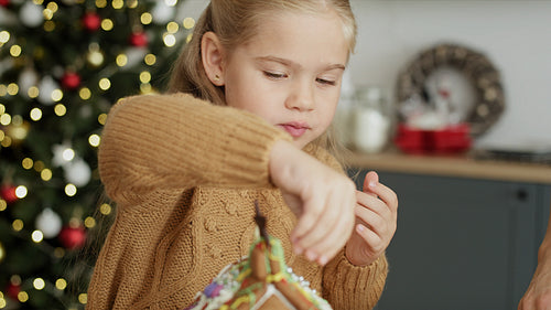 Video of cute girl decorating gingerbread house