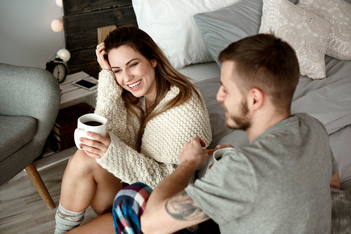 Cheerful couple with coffee talking and laughing
